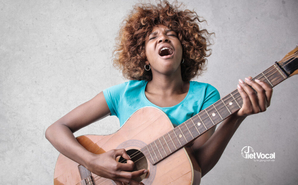 alt text: Hình ảnh một người đàn ông đang chơi guitar và hát