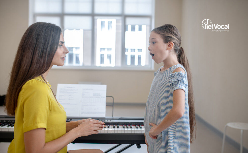 alt text: Một người đang học hát với giáo viên
